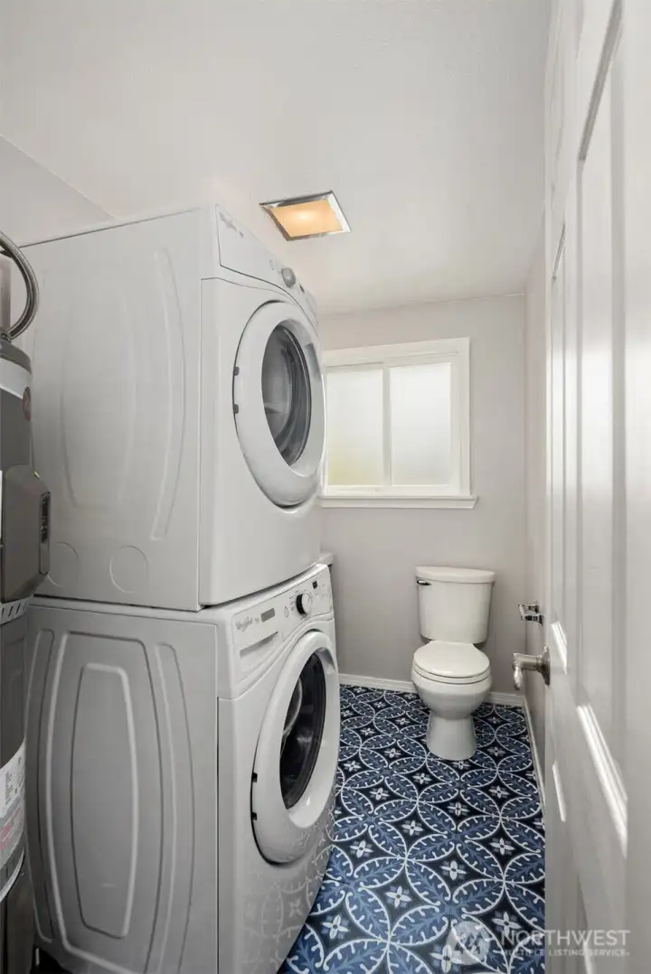 Laundry room with stackable washer and dryer and new water heater.