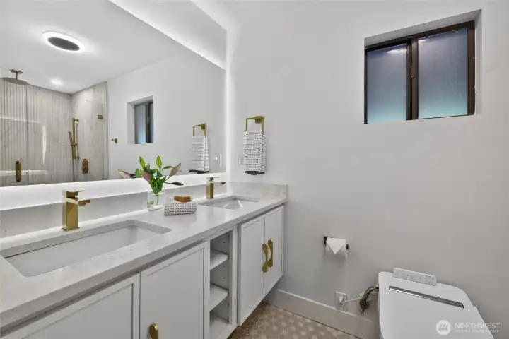Primary bath with floating dual vanity, heated tile floors, backlit LED mirror, and bidet toilet with remote control.