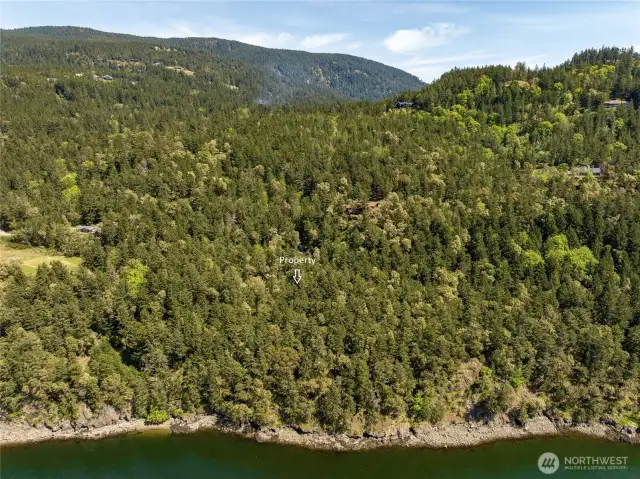 Property from the water. Sandy pocket beach lower left, with larger rocky water access just to the right