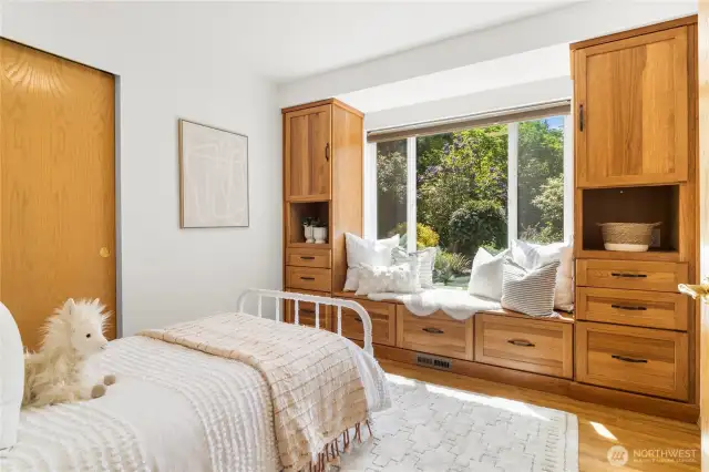 Second bedroom with beautiful custom built ins and a charming, functional window seat view of the garden.