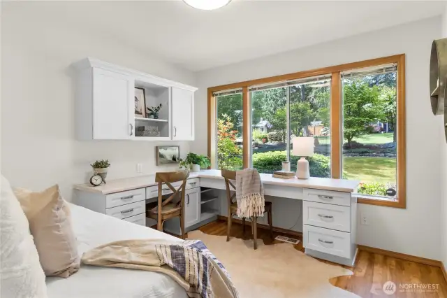 Third bedroom with custom built-ins and beautiful framed windows highlighting the front yard.