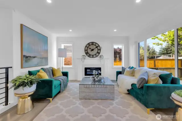 Large picture window and electric fireplace create a luxuriously cozy atmosphere - 8042 19th Ave NW, Seattle, WA 98117