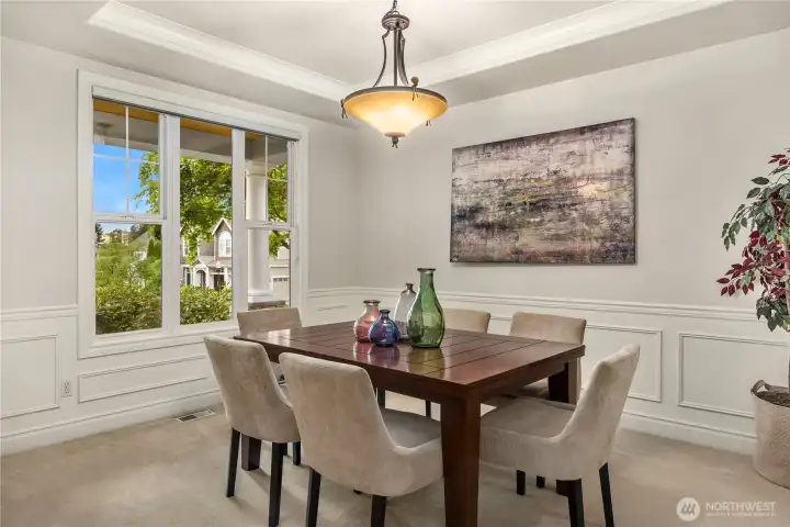 Beautiful architectural details, including tray ceilings and wainscoting, enhance the home’s charm, while expansive windows flood the space with natural light.
