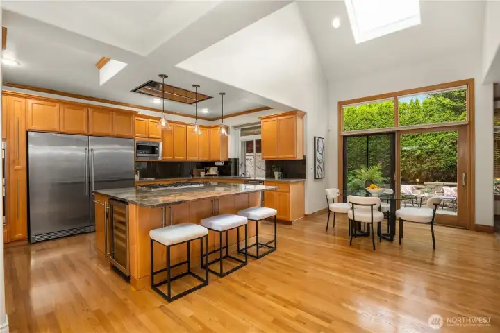 Light-filled chef’s kitchen with vaulted ceilings and skylight creates an inviting central gathering space.
