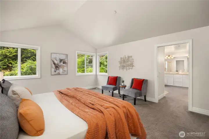 Primary bedroom features double door entry, vaulted ceilings and large windows.