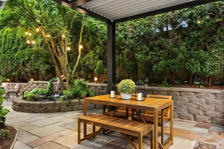 Inviting seating area beneath a custom-built luxury pergola with integrated lighting and heaters.