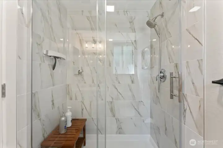 Elegant walk-in shower features beautiful marble-look tile surround. Elegant walk-in shower features beautiful marble-look tile surround.