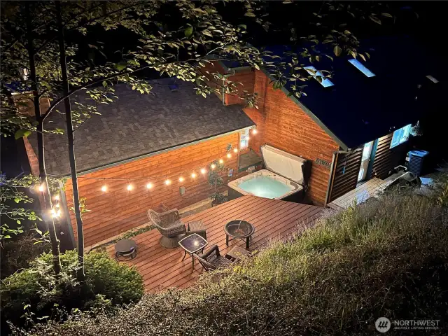 Back of the home at twilight from upper terrace.  Note the skylights.
