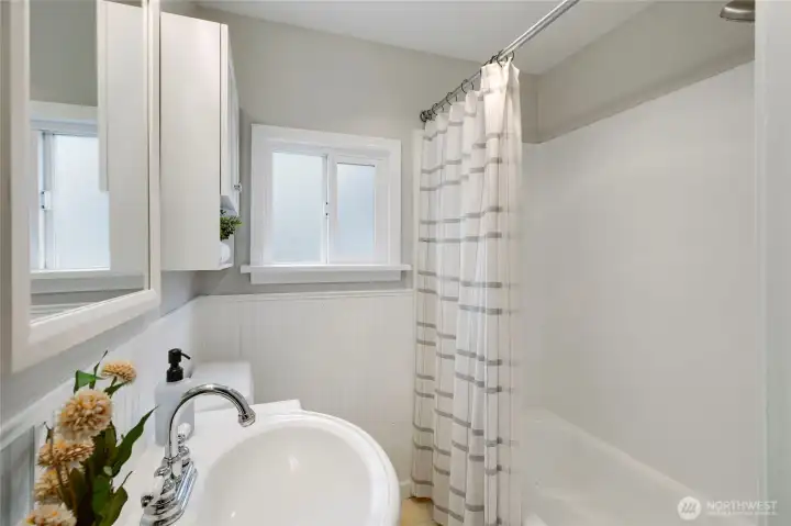 Bathroom features ample natural light and a neutral color palette.