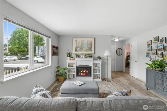 The living room features a large window for an abundance of natural light. The hallway leads to 2 bedrooms and a bathroom.