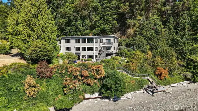 Back and side of the home. Easy access to your own 150 feet of waterfront with tideland rights, your own mooring buoy and where beachcombing and endless memories are made.