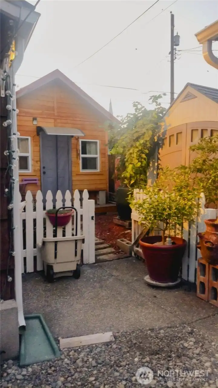 This is the separate yard for the detached studio that is used as a third bedroom.   It was built on site in the back corner of the yard.  There is a second storage shed on the property that is movable and next to the grape arbor  To the left of the studio is a path that leads to the two car garage