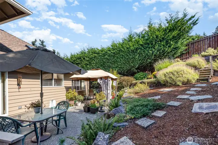 The serene, fully fenced backyard offers two patios & beautifully designed spaces.