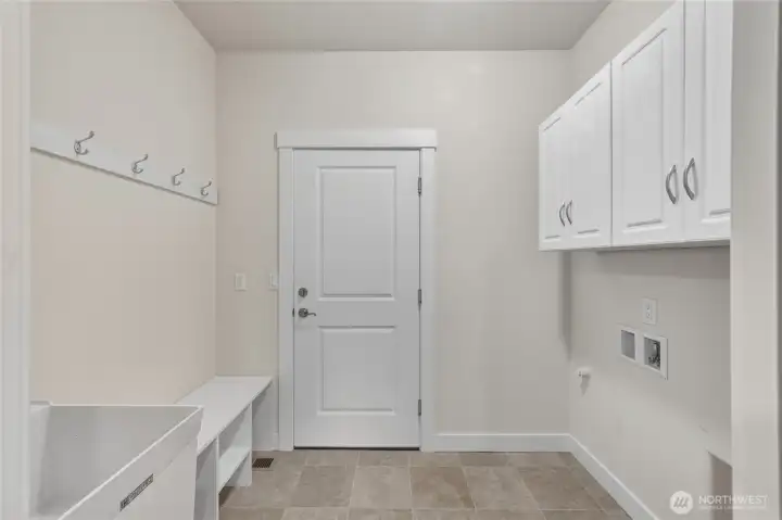 The laundry room has storage and hooks and connects to the 2 car garage.