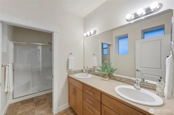 The attached spacious primary bathroom with separate shower and toilet room.