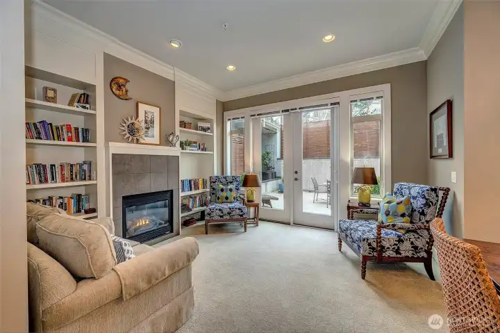 Living area is highlighted with custom crown moldings, built in bookshelves surround the cozy gas fireplace while French door leads to private, spacious sun-drenched patio.