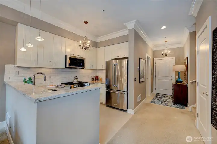 Chef's kitchen has updated quartz countertops, full height backsplash and loads of cabinet space.