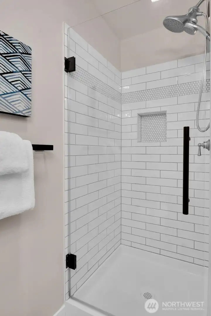 Hall bath features a beautiful glass shower door.