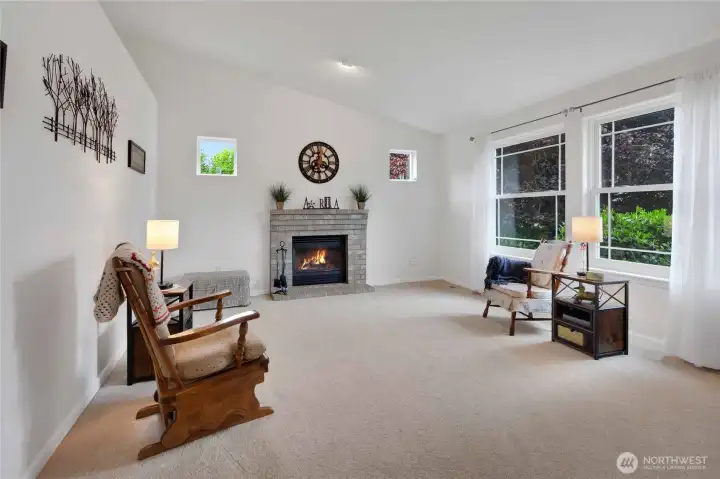 Living room with vaulted ceiling and propane fireplace.  New Anderson windows open to the front yard.