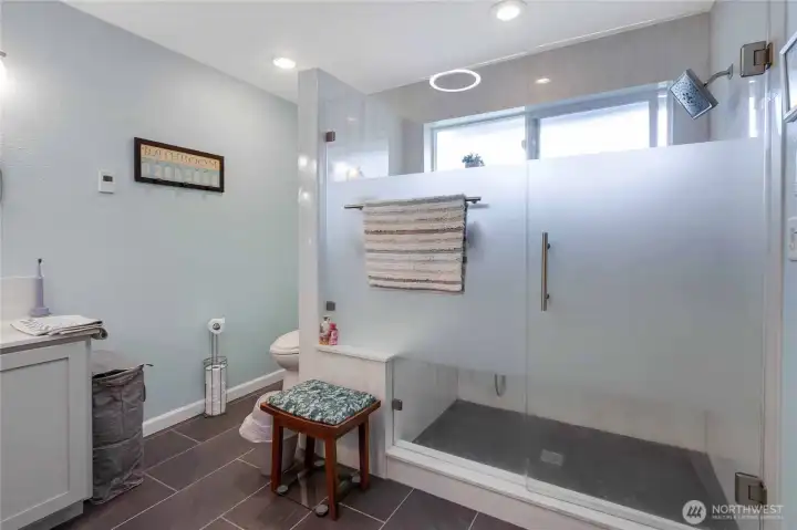 Oversized walk in shower with bench and lots of options for shower heads!