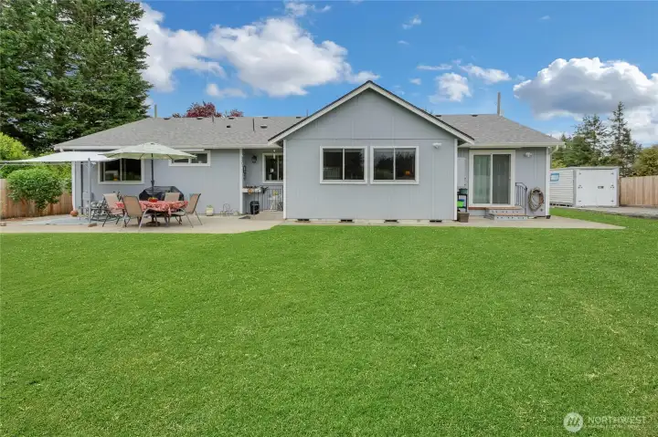 Backyard patio is spacious and offers sunshade that stays with the home.  Wow...Look at the new roof too!  RV Parking to the right.
