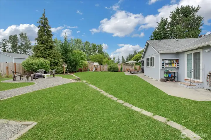 Backyard is landscaped nicely with retaining wall and oversized patio and grass areas.