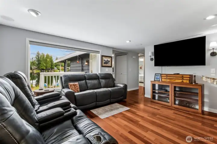 The family room offers a relaxed space for movie nights, reading, or casual gatherings. Large windows keep the lake in sight, making the room feel bright and connected to the outdoors.