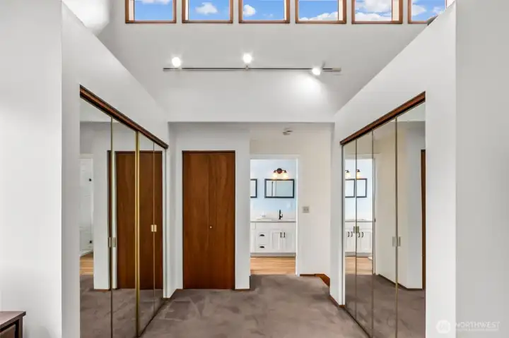 The owner’s suite feels open and airy with its vaulted ceiling and clerestory windows that pull in soft natural light throughout the day. Three generous closets add practical storage without sacrificing the room’s spacious feel. It’s an attractive, well-designed retreat that blends comfort, function, and elevated style.
