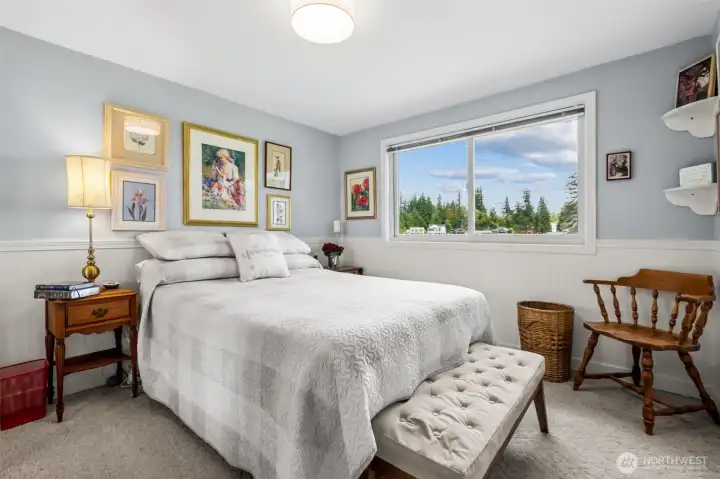 Bedroom #2 on the main floor, lake views and soft, beachy colors. Three main-floor bedrooms offer flexibility for guests or work-from-home needs. Each room is filled with natural light and peaceful views.