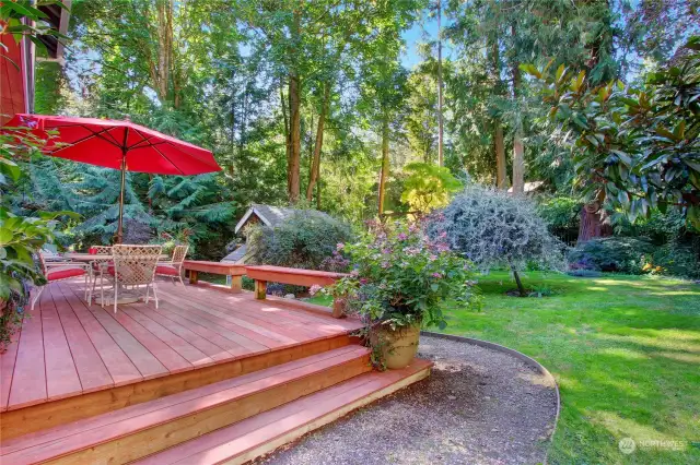 Expansive Trex decking with built-in benches overlooks picturesque yard and gardens.