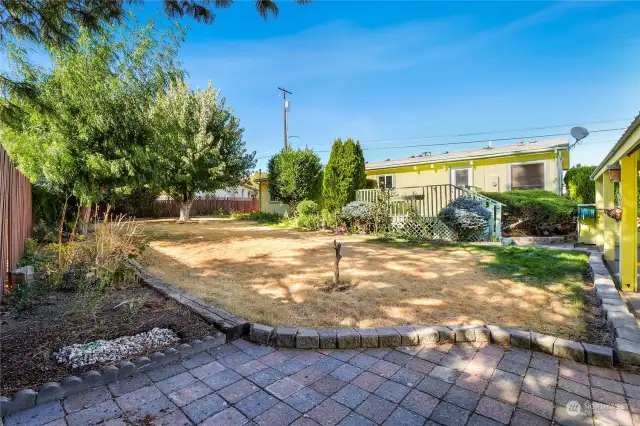 What a large backyard with all those shrubs and the garden space. The pavers give it extra dimension. A little water on the grass and it should come back to life in a matter of weeks!