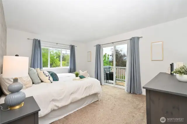 Generously sized primary bedroom with sitting area, walk-in closet, adjoined primary bath, and a private balcony with mountain and partial sound views.