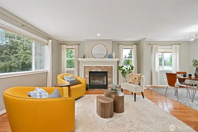 Hardwood floors, gas fireplace, and picture windows accentuate the light filled living area.
