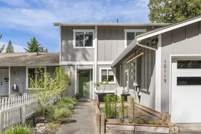 The green door is the front door entry to the townhome. Unit on the left with the lower roof line is not part of the townhome that is for sale.