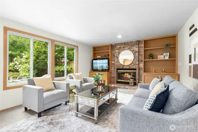 Inviting family room with a fireplace and a wall of light filling windows.