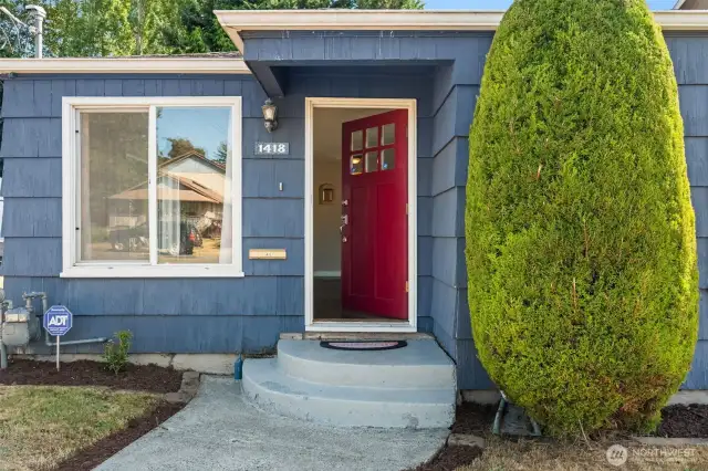 The warm exterior color palette and large picture window hint at the bright, inviting interiors within.