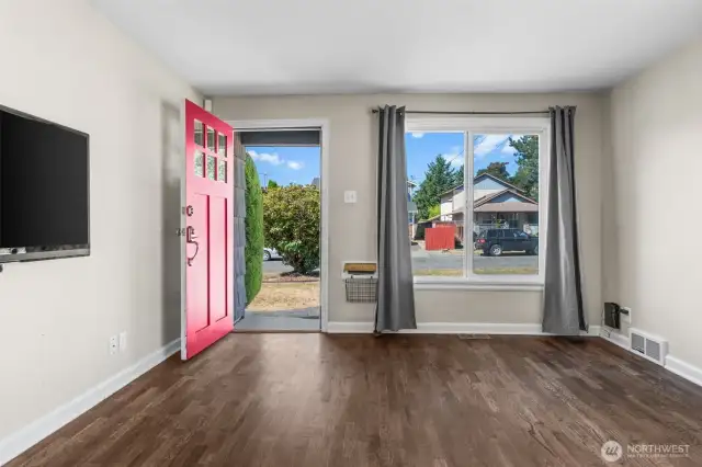 Entryway features a large window and solid front door, setting a warm tone as you step inside.