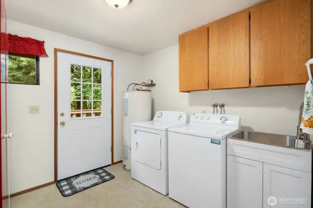 Large Utility room with sink, washer and dryer. Access to back deck.