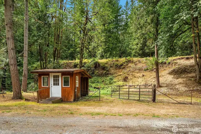 Partially fenced acreage with outbuilding, previously used for goat house.