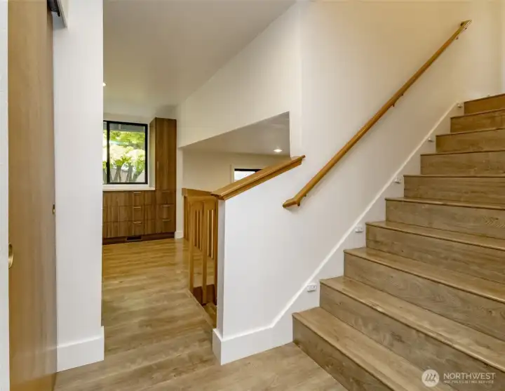 From entry, stairway to upper level, coat closet on left
