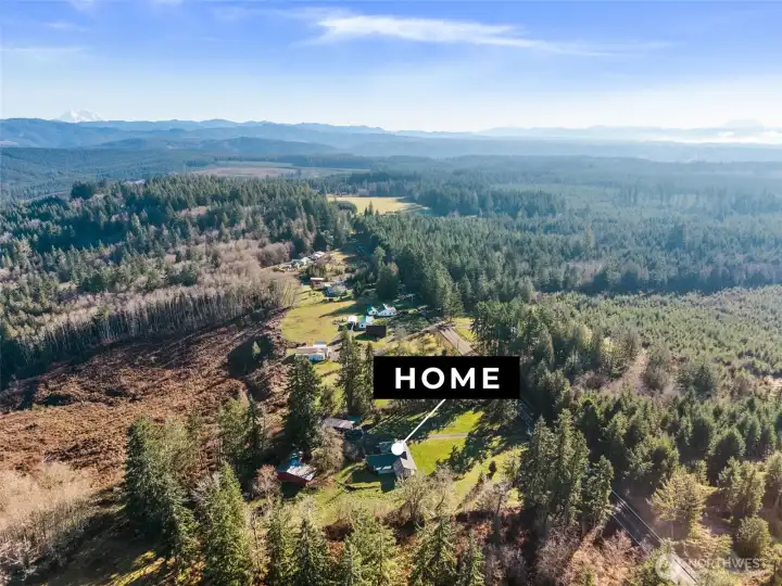 Peaceful country surroundings with open land and treed backdrop for privacy.