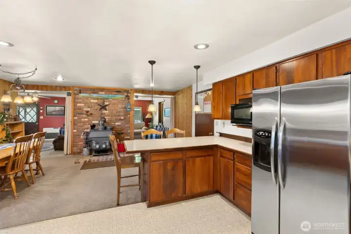 Brick hearth with wood stove provides both warmth and rustic appeal, perfect for a cozy gathering around the table.
