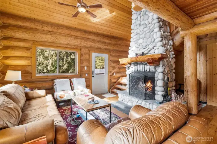 Main living space with custom wood-burning stone fireplace.