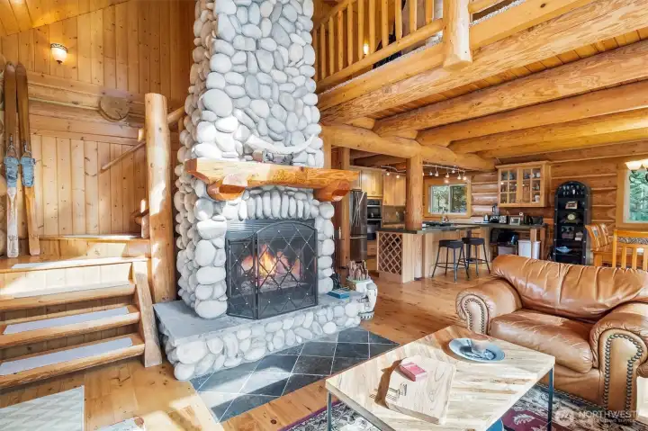 Custom stone, wood-burning fireplace adjacent to stairwell.