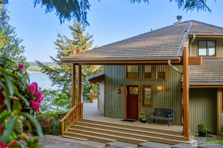 Covered front entry offers a charming arrival with peaceful water glimpses nearby.