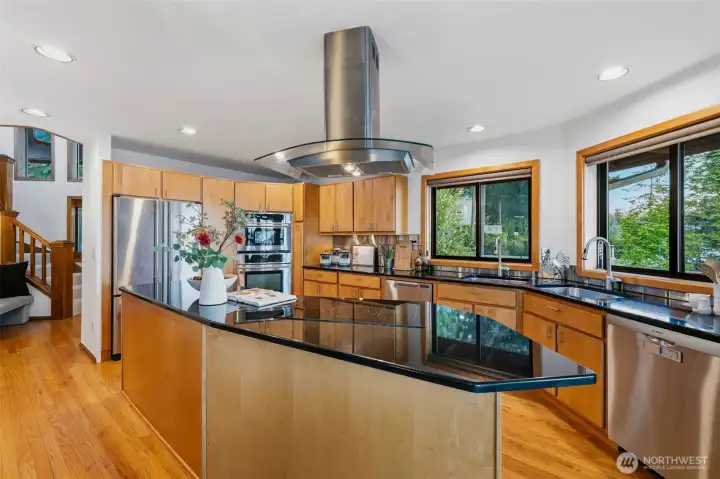Spacious kitchen featuring expansive counter space, stainless steel appliances, and hardwood floors.