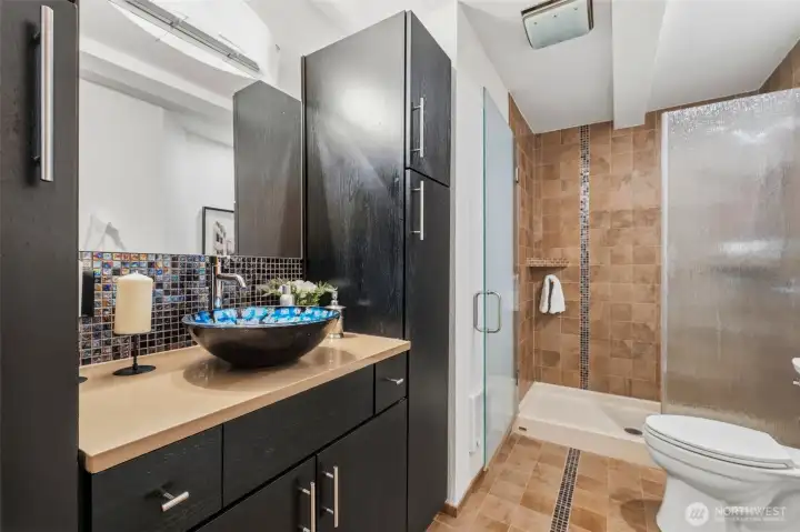 Stylish bathroom featuring a vessel sink vanity, tiled shower, and modern finishes.