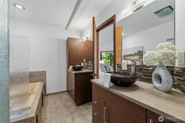 Spacious en suite bath featuring dual vanities, modern vessel sinks, and generous storage.