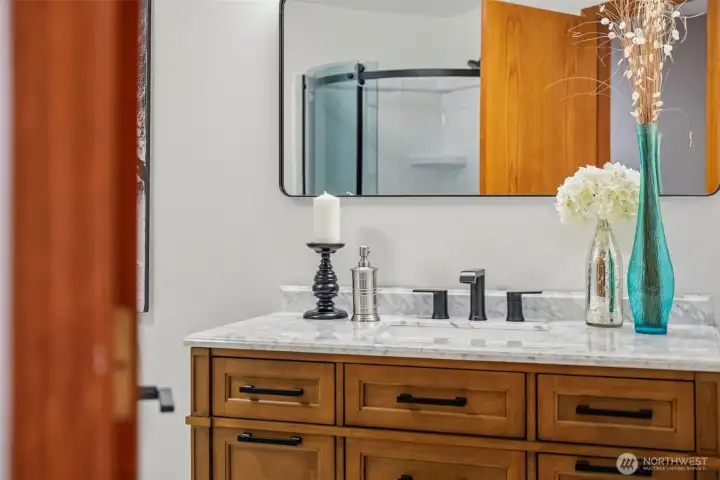 Thoughtfully updated bathroom featuring rich wood tones and elegant finishes.