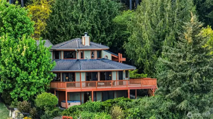 Private waterfront setting surrounded by lush greenery and established trees.